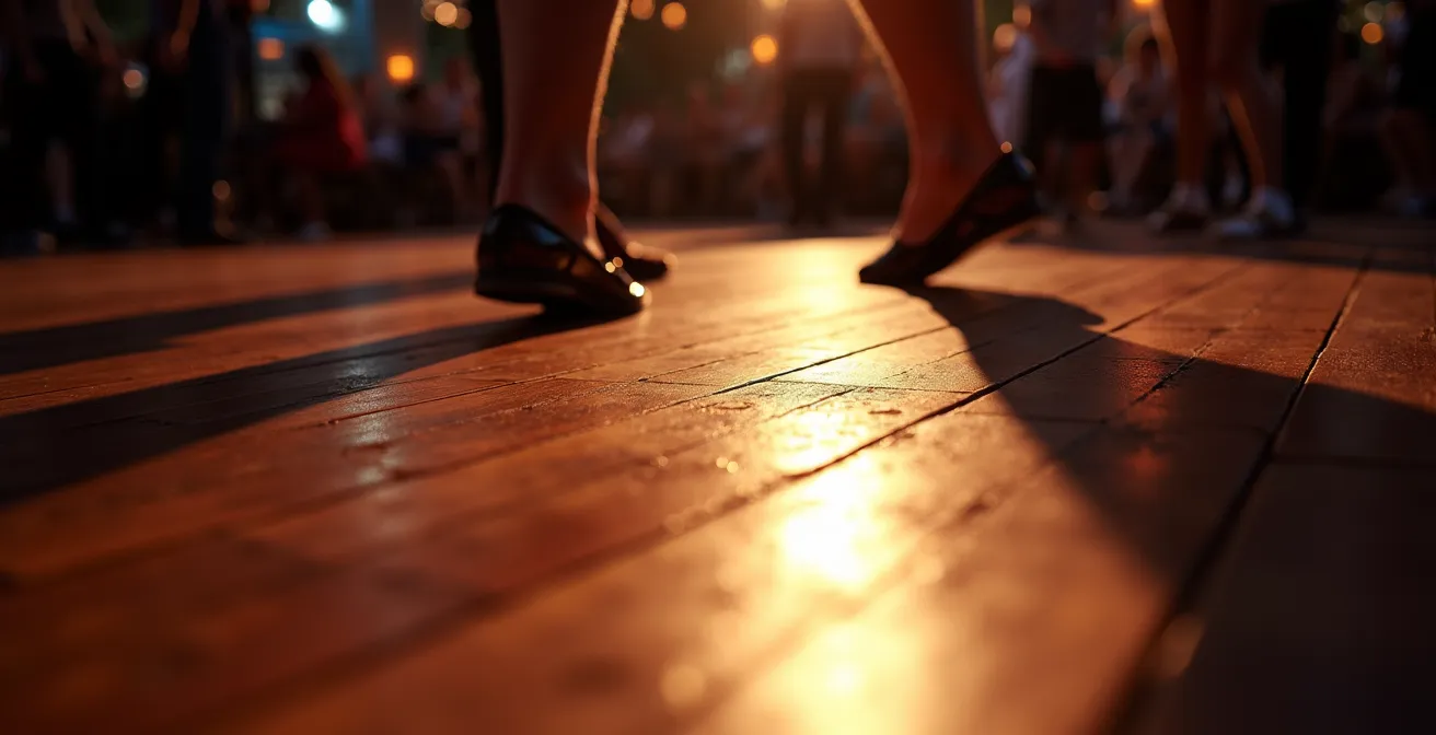 A close-up shot of a wooden venue floor where a diagonal line separates the brightly lit dance floor from an area of deep shadow, illustrating the concept of negative space.