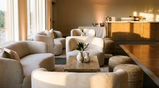 Wedding reception lounge area positioned between bar and dance floor with plush seating at golden hour