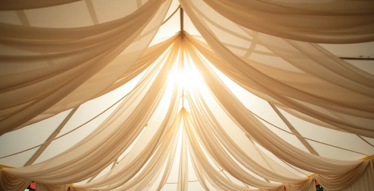 Interior view of wedding tent with layered fabric draping creating pockets of diffused light